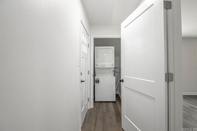 hall featuring wood-type flooring and stacked washing maching and dryer