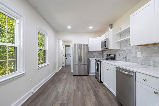 kitchen with dark hardwood / wood-style flooring, white cabinetry, sink, and appliances with stainless steel finishes