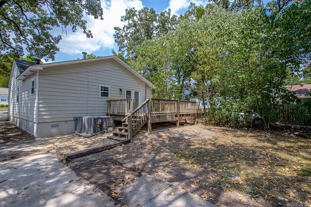 rear view of house with a deck and central AC