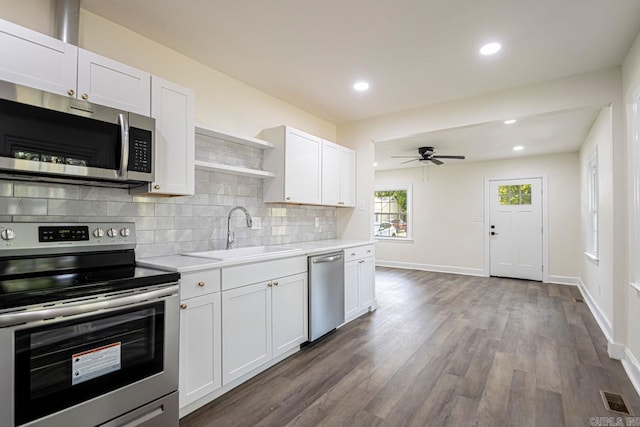 kitchen with white cabinetry, sink, appliances with stainless steel finishes, and dark wood-type flooring