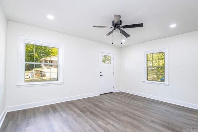 spare room featuring plenty of natural light, dark wood-type flooring, and ceiling fan