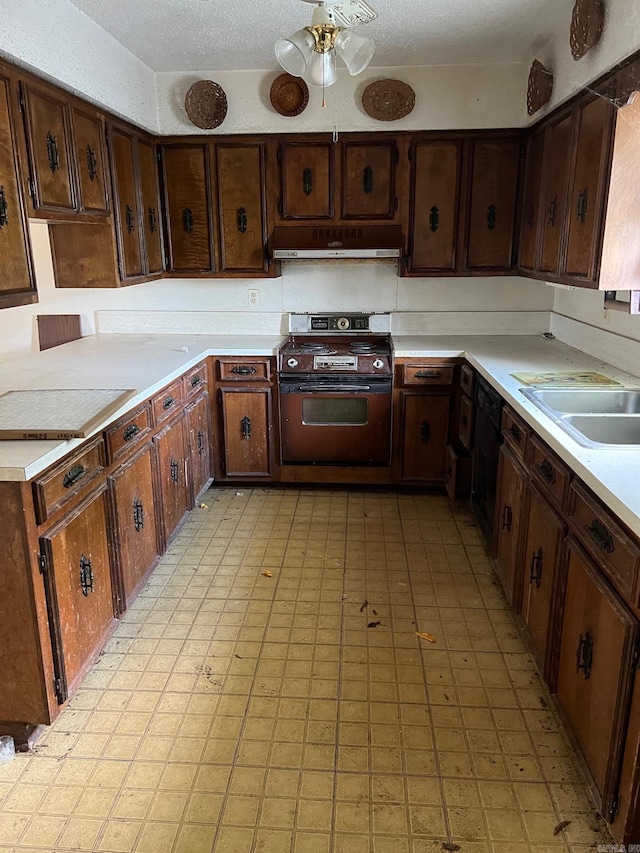 kitchen featuring stove, sink, a textured ceiling, dark brown cabinets, and extractor fan