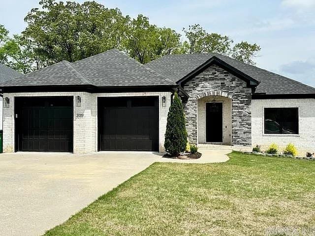 view of front of home with a front yard and a garage