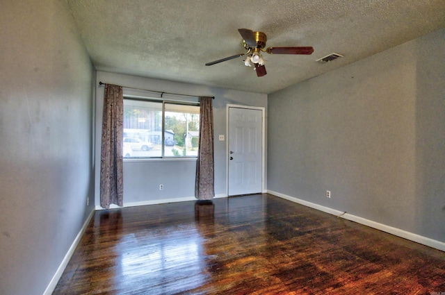 unfurnished room featuring ceiling fan, dark hardwood / wood-style flooring, and a textured ceiling