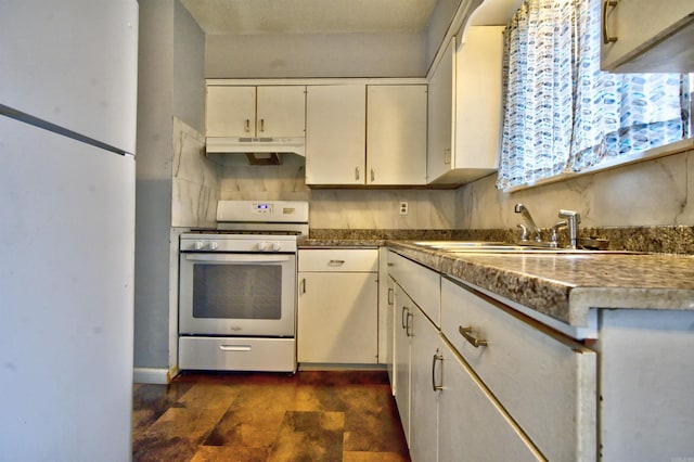 kitchen featuring decorative backsplash, white appliances, dark stone countertops, and sink