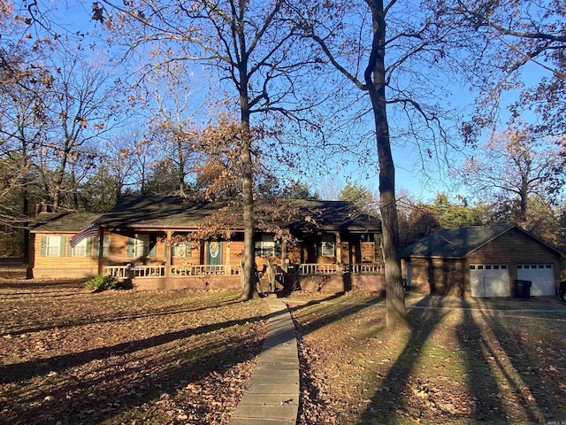 single story home featuring covered porch, a garage, and an outdoor structure