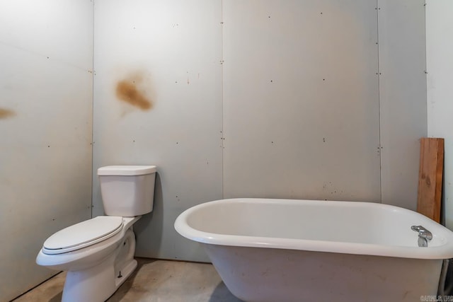 bathroom featuring a bathtub, concrete floors, and toilet