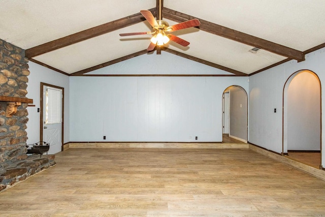 unfurnished living room with vaulted ceiling with beams, light hardwood / wood-style flooring, ceiling fan, and a stone fireplace