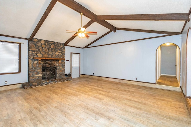 unfurnished living room with lofted ceiling with beams, a fireplace, ceiling fan, and light hardwood / wood-style floors