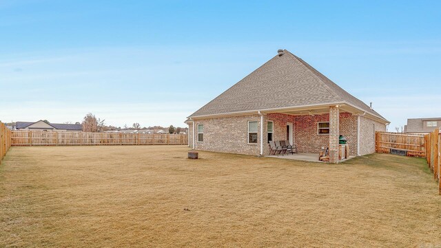 back of house with a yard and a patio area