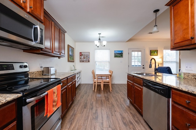 kitchen featuring sink, pendant lighting, dark hardwood / wood-style flooring, and stainless steel appliances