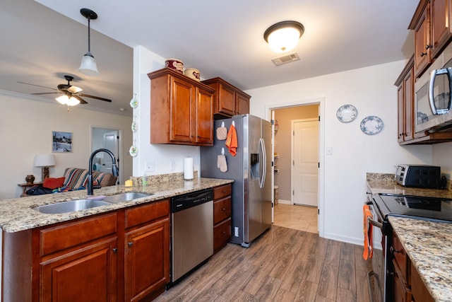 kitchen with ceiling fan, sink, hardwood / wood-style floors, appliances with stainless steel finishes, and ornamental molding