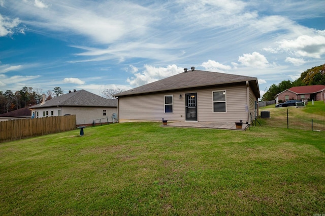 rear view of house with a patio and a lawn