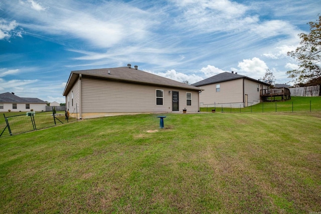 rear view of property featuring a lawn