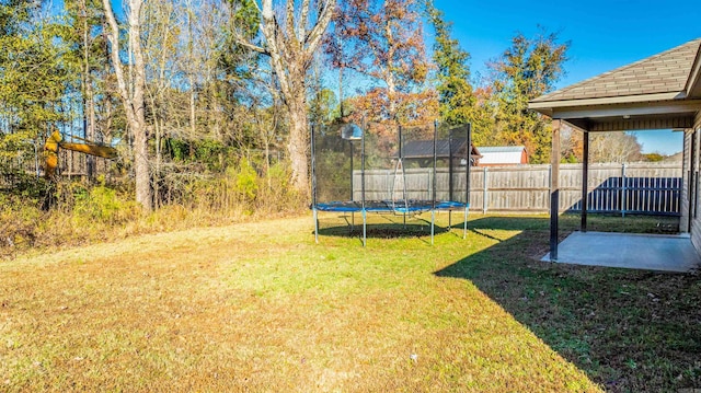 view of yard featuring a trampoline and a patio