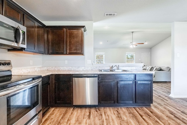 kitchen featuring dark brown cabinets, light hardwood / wood-style floors, sink, and appliances with stainless steel finishes