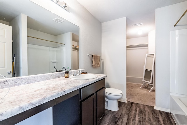 full bathroom with hardwood / wood-style flooring, vanity, toilet, and shower / washtub combination