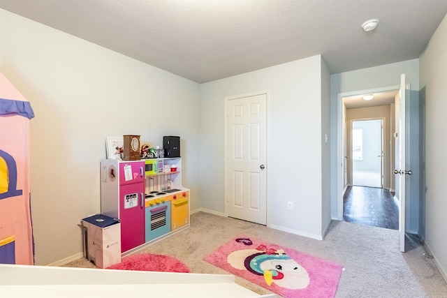 game room featuring light carpet and a textured ceiling