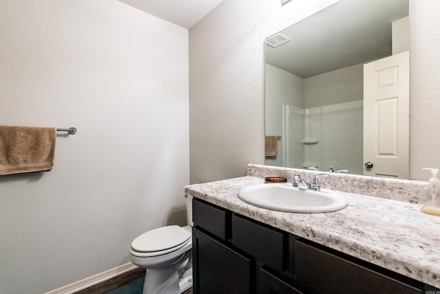 bathroom with vanity, toilet, and a shower