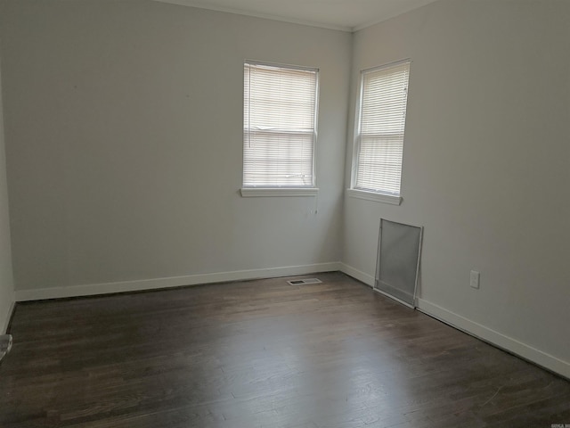 spare room featuring dark hardwood / wood-style floors and crown molding