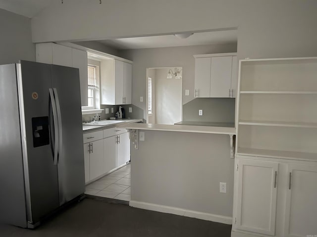 kitchen featuring white cabinetry, stainless steel fridge with ice dispenser, tile patterned flooring, and sink