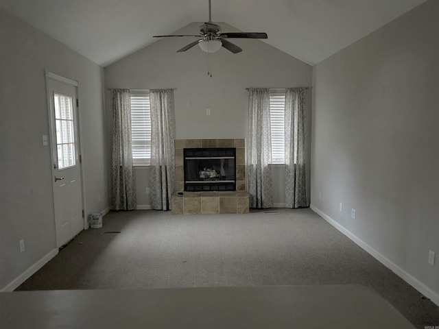 unfurnished living room with carpet, ceiling fan, lofted ceiling, and a tiled fireplace