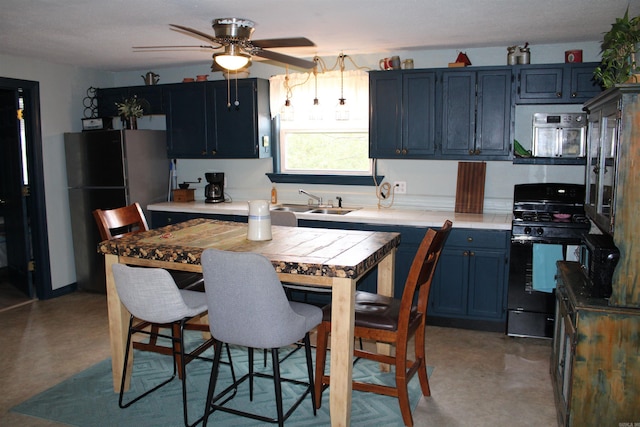 kitchen featuring ceiling fan, refrigerator, black gas range oven, and blue cabinets