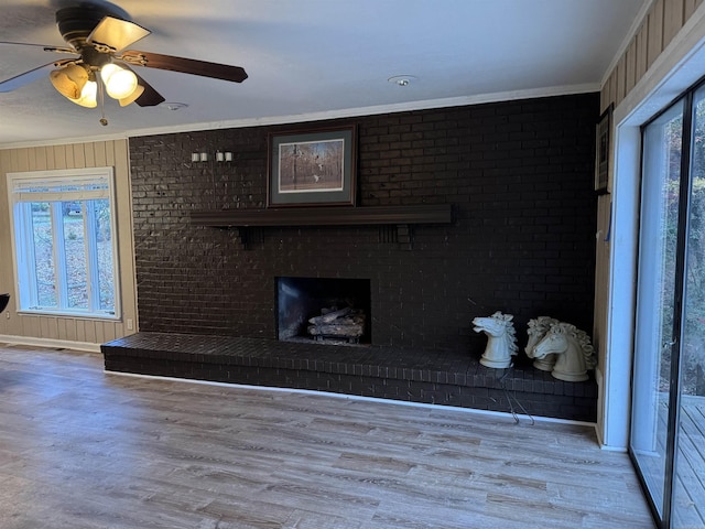 unfurnished living room featuring light wood-type flooring, plenty of natural light, and ornamental molding