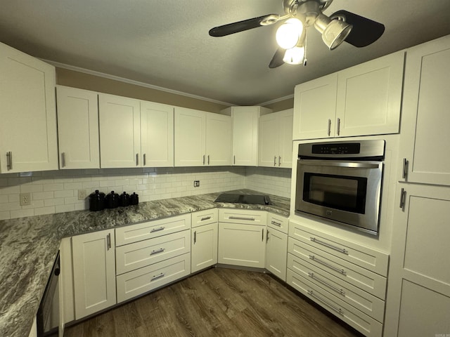 kitchen with crown molding, stainless steel oven, white cabinets, and dark hardwood / wood-style floors