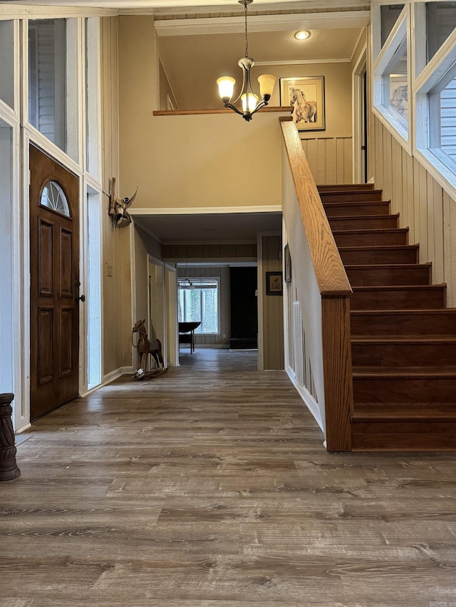 foyer featuring a chandelier, hardwood / wood-style flooring, and ornamental molding