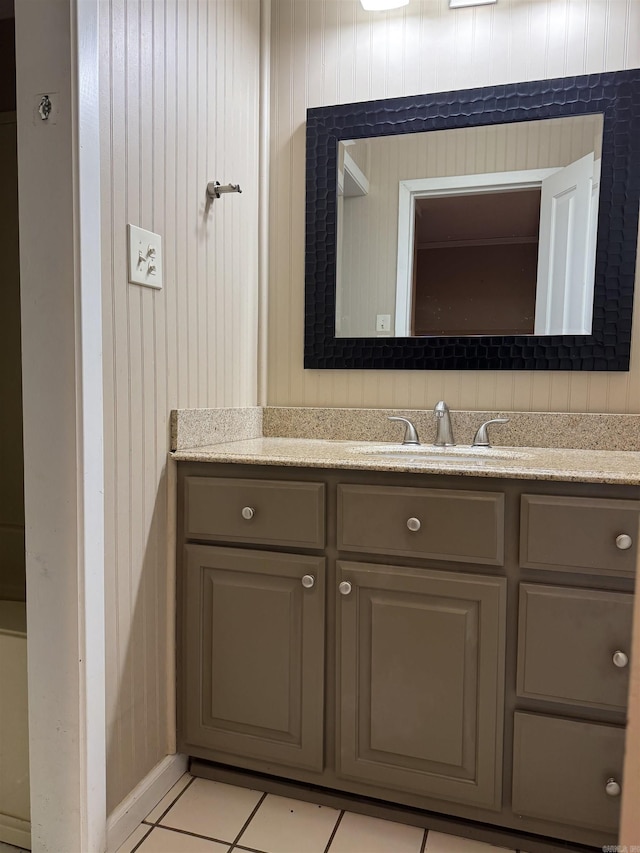 bathroom featuring tile patterned flooring, vanity, and wooden walls