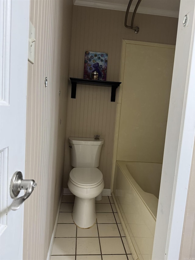 bathroom featuring a bathing tub, crown molding, tile patterned flooring, and toilet