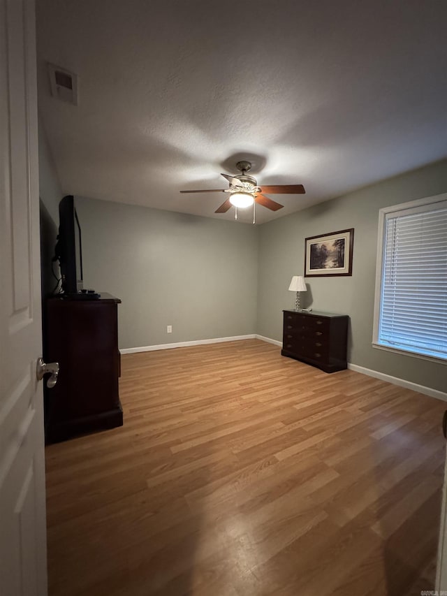 unfurnished bedroom featuring hardwood / wood-style floors, a textured ceiling, and ceiling fan