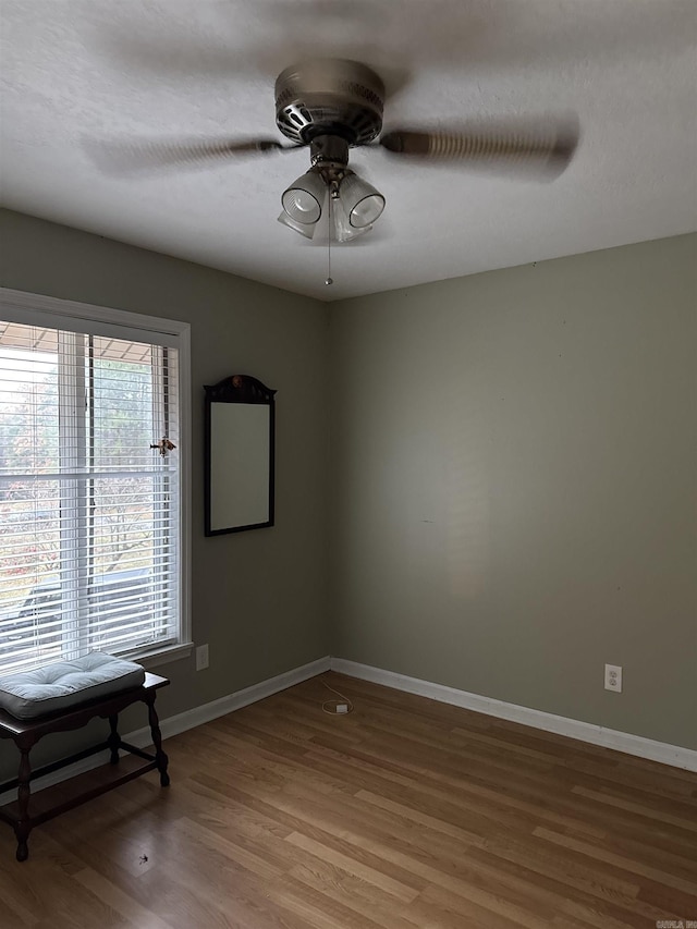 empty room with ceiling fan and wood-type flooring