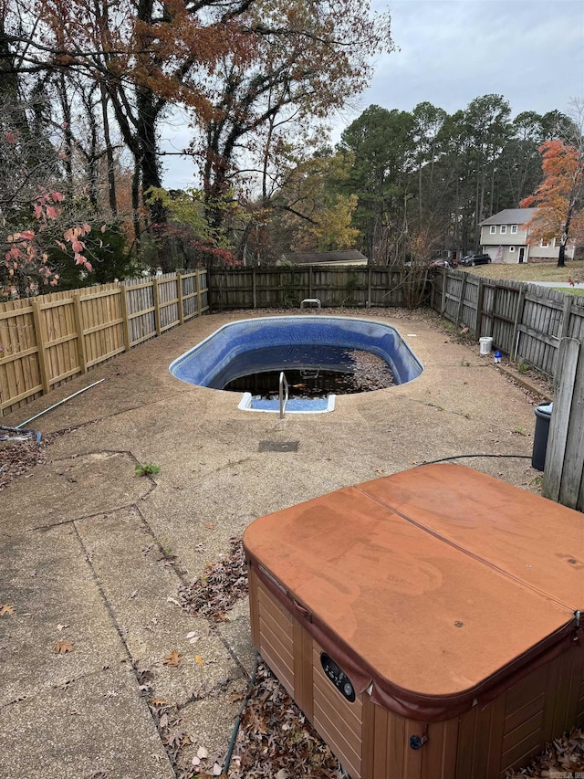 view of swimming pool featuring a hot tub