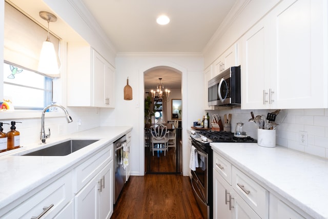 kitchen featuring sink, dark wood-type flooring, stainless steel appliances, decorative light fixtures, and white cabinets