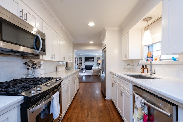 kitchen featuring dark hardwood / wood-style flooring, stainless steel appliances, sink, white cabinetry, and hanging light fixtures