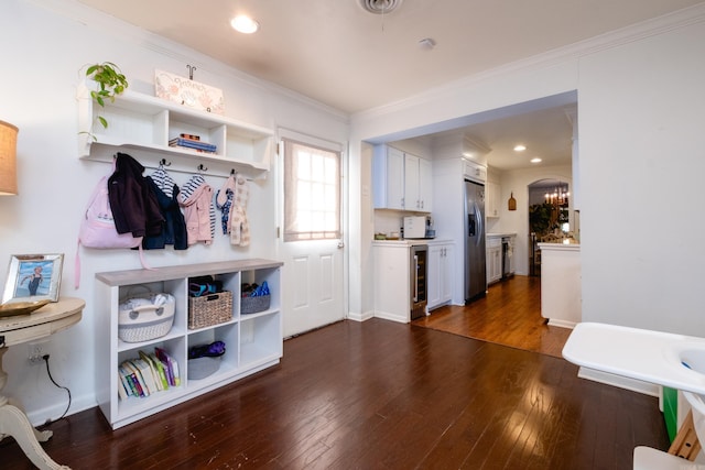 mudroom with wine cooler, a notable chandelier, dark hardwood / wood-style floors, and ornamental molding