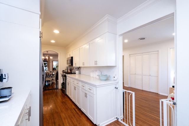 kitchen featuring white cabinets, dark wood-type flooring, appliances with stainless steel finishes, and tasteful backsplash