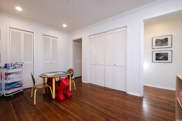 playroom with crown molding and dark wood-type flooring