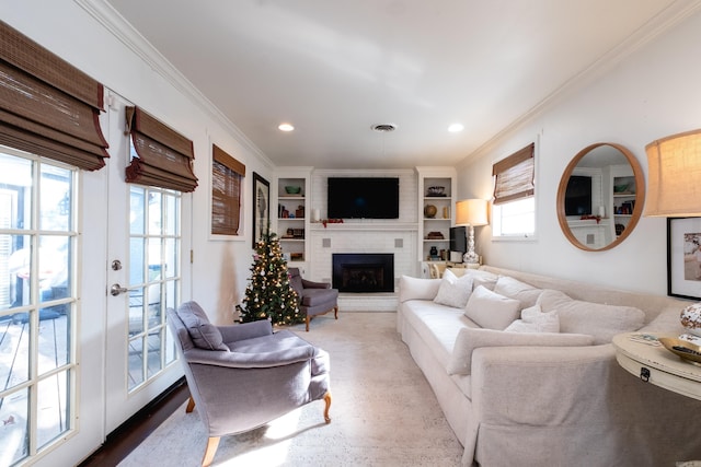 living room featuring built in shelves, a fireplace, french doors, and ornamental molding