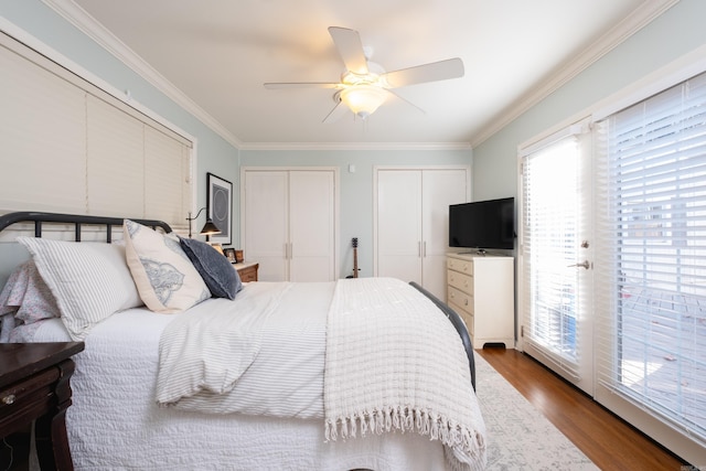 bedroom featuring hardwood / wood-style flooring, ceiling fan, crown molding, and multiple windows