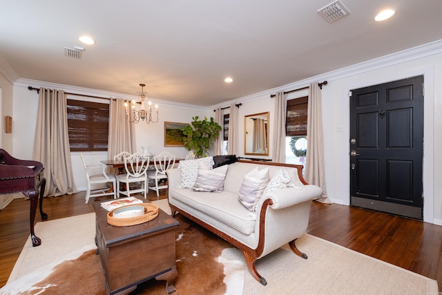 living room featuring crown molding, dark hardwood / wood-style flooring, and a notable chandelier