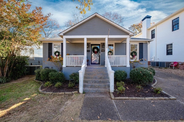 bungalow-style home with cooling unit and a porch