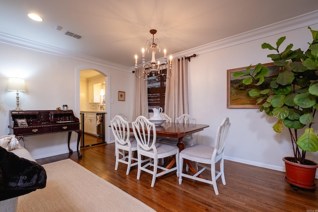 dining room featuring crown molding, a chandelier, and dark hardwood / wood-style floors