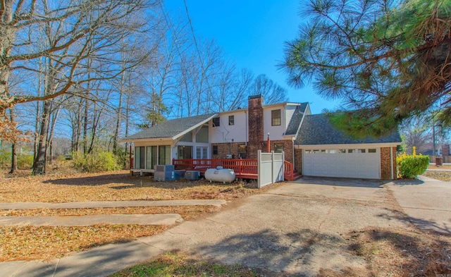 view of front facade with a deck, a garage, and a sunroom