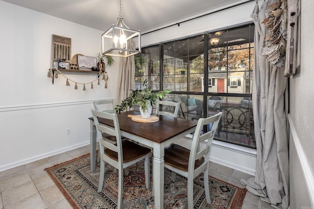 tiled dining room with a chandelier