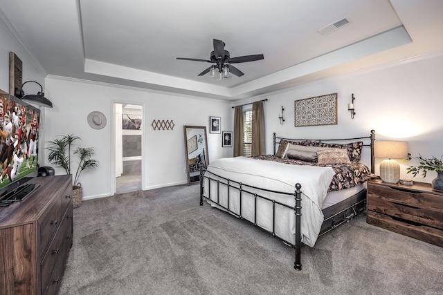 bedroom with carpet, a tray ceiling, ceiling fan, and ornamental molding