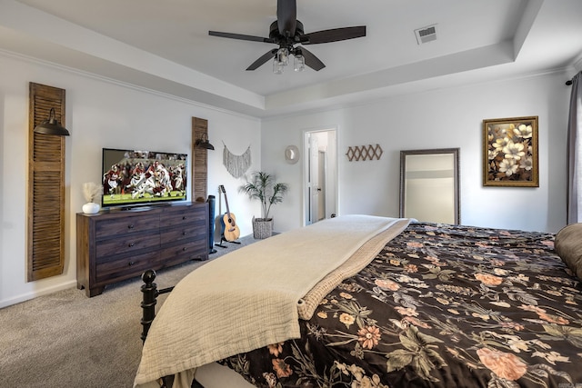 bedroom with a tray ceiling, ceiling fan, light colored carpet, and ornamental molding