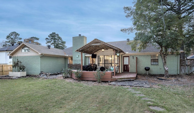 rear view of house with a deck and a lawn